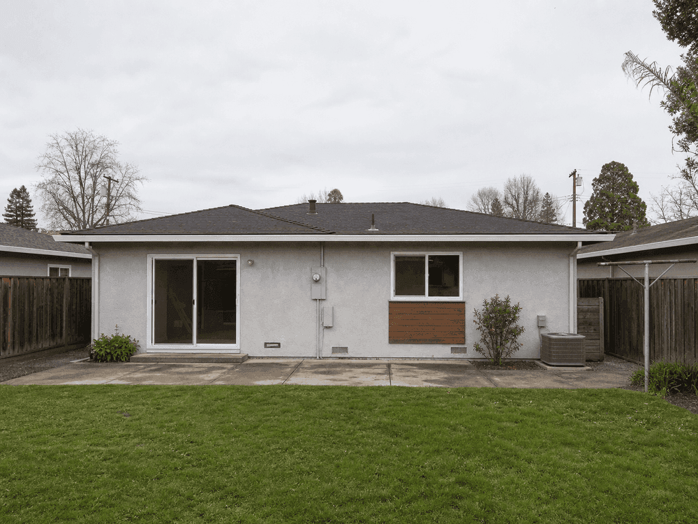Rear yard view showing original low roofline before the second story was added